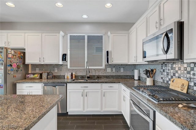 1120 Via Della Curia, Henderson, NV 89011 - kitchen featuring appliances with stainless steel finishes, a sink, white cabinets, decorative backsplash, and recessed lighting
