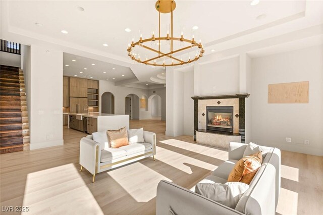8895 S Tenaya Way, Las Vegas, NV 89113 - living area with arched walkways, a chandelier, light wood finished floors, recessed lighting, and stairs