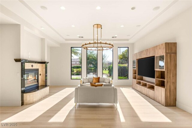 8895 S Tenaya Way, Las Vegas, NV 89113 - living area featuring a tiled fireplace, light wood-type flooring, recessed lighting, a chandelier, and a raised ceiling