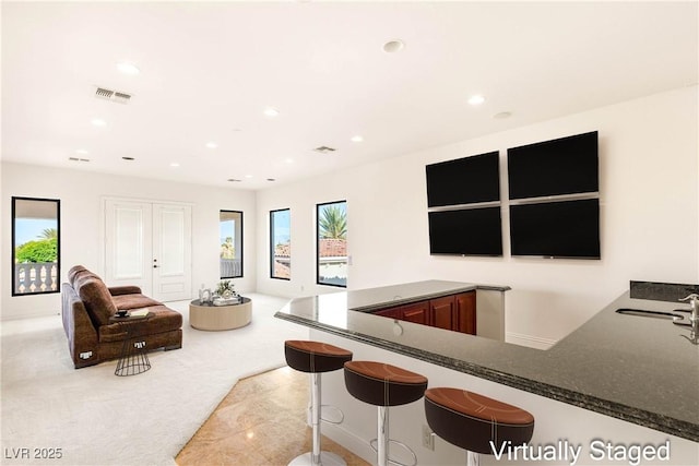 8895 S Tenaya Way, Las Vegas, NV 89113 - kitchen featuring recessed lighting, open floor plan, dark stone counters, carpet floors, and a breakfast bar area