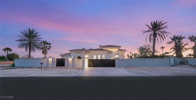 8895 S Tenaya Way, Las Vegas, NV 89113 - mediterranean / spanish-style home with driveway, a gate, a fenced front yard, and stucco siding