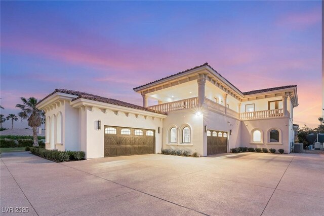8895 S Tenaya Way, Las Vegas, NV 89113 - mediterranean / spanish-style house featuring a balcony, concrete driveway, stucco siding, and a garage