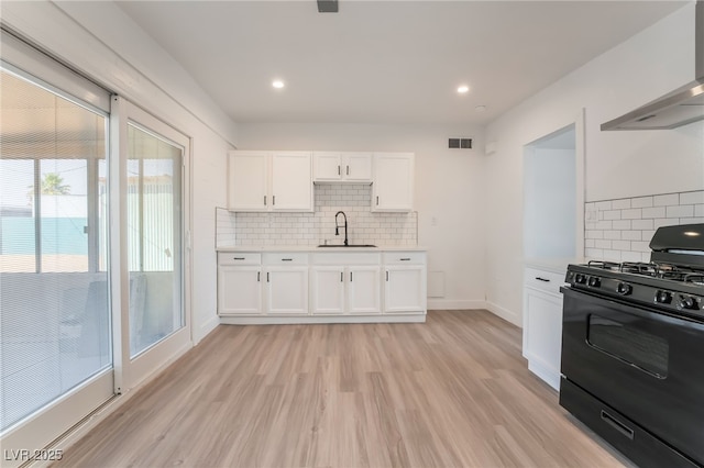 3200 E Owens Ave, North Las Vegas, NV 89030 - kitchen featuring gas stove, a sink, wall chimney range hood, light countertops, and tasteful backsplash