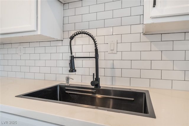 3200 E Owens Ave, North Las Vegas, NV 89030 - kitchen view of a sink, tasteful backsplash, light countertops, and white cabinetry