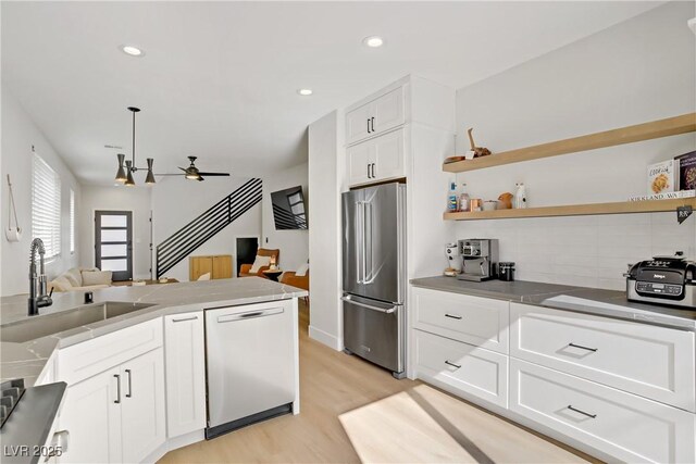 305 Napa Hills Dr, Las Vegas, NV 89144 - kitchen featuring stainless steel appliances, a ceiling fan, light wood finished floors, backsplash, and white cabinets