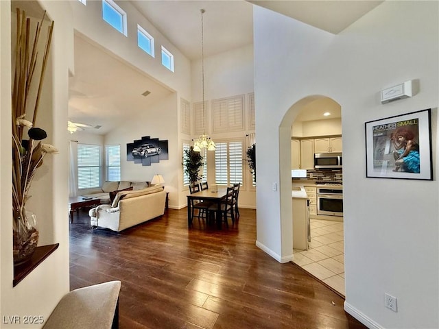 1704 Cordoba Canyon St, Las Vegas, NV 89117 - living area featuring arched walkways, a towering ceiling, wood finished floors, plenty of natural light, and ceiling fan