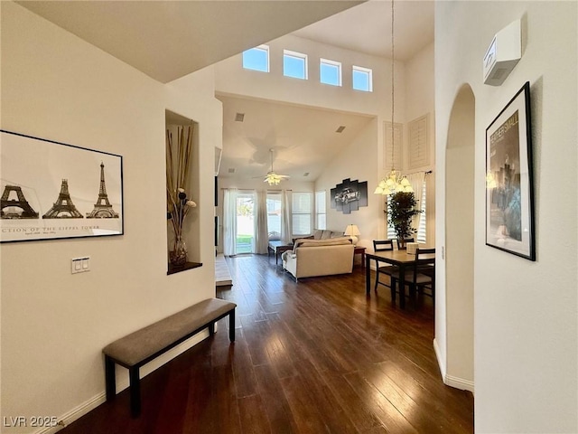 1704 Cordoba Canyon St, Las Vegas, NV 89117 - hall featuring dark wood finished floors, baseboards, a towering ceiling, and arched walkways