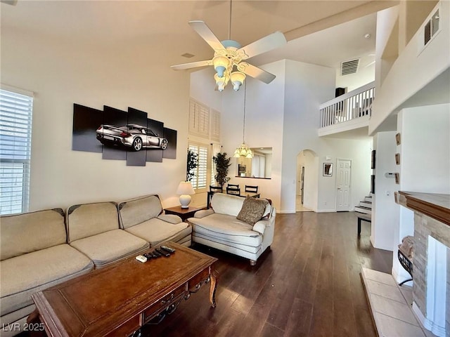 1704 Cordoba Canyon St, Las Vegas, NV 89117 - living area featuring a towering ceiling, a ceiling fan, arched walkways, wood finished floors, and stairs