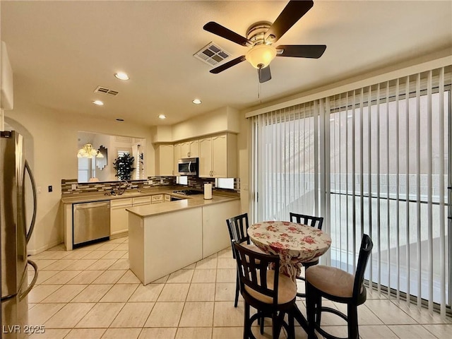 1704 Cordoba Canyon St, Las Vegas, NV 89117 - kitchen featuring appliances with stainless steel finishes, a peninsula, light tile patterned flooring, ceiling fan, and recessed lighting