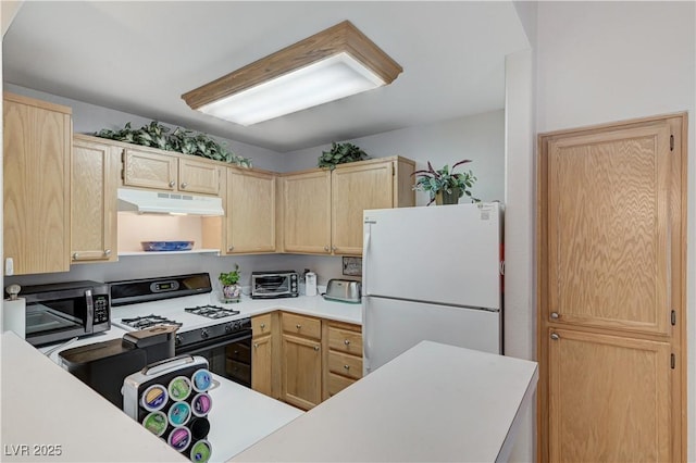 8450 Alta Dr Unit 204, Las Vegas, NV 89145 - kitchen with freestanding refrigerator, under cabinet range hood, stainless steel microwave, gas range oven, and light brown cabinets