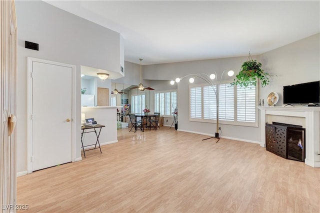 8450 Alta Dr Unit 204, Las Vegas, NV 89145 - living area with wood finished floors, a fireplace, baseboards, and ceiling fan