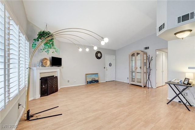 8450 Alta Dr Unit 204, Las Vegas, NV 89145 - unfurnished living room with a fireplace, light wood-style floors, plenty of natural light, and baseboards