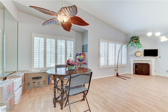 8450 Alta Dr Unit 204, Las Vegas, NV 89145 - dining room with lofted ceiling, a ceiling fan, light wood-style floors, plenty of natural light, and a fireplace