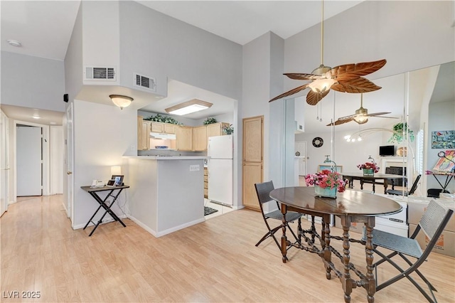 8450 Alta Dr Unit 204, Las Vegas, NV 89145 - dining area featuring a high ceiling, ceiling fan, light wood finished floors, and baseboards