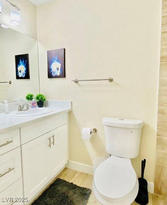 6320 Shawnee Ave, Las Vegas, NV 89107 - bathroom featuring vanity, toilet, baseboards, and wood finished floors
