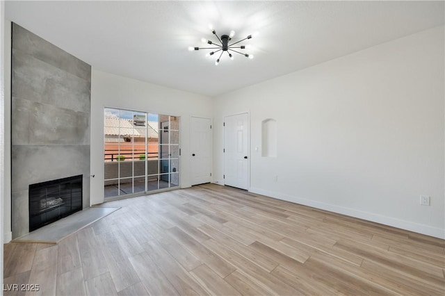 3318 N Decatur Blvd Unit 1107, Las Vegas, NV 89130 - unfurnished living room featuring a chandelier, light wood-style floors, a fireplace, and baseboards