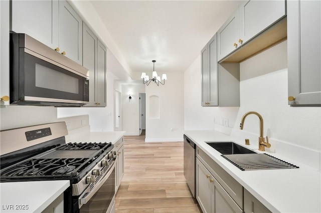 3318 N Decatur Blvd Unit 1107, Las Vegas, NV 89130 - kitchen featuring stainless steel appliances, a chandelier, light countertops, light wood finished floors, and a sink
