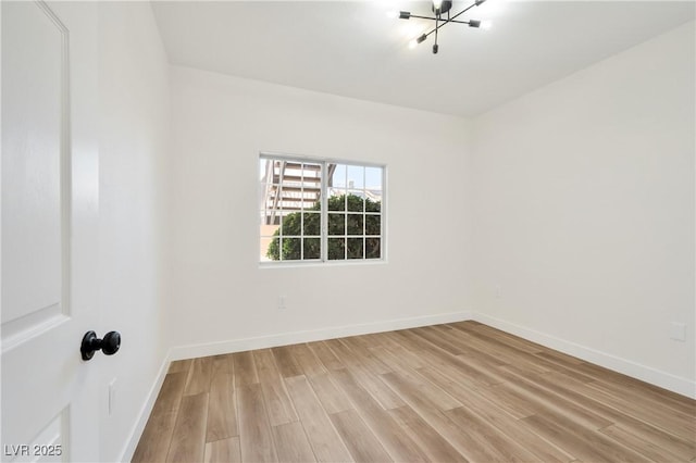 3318 N Decatur Blvd Unit 1107, Las Vegas, NV 89130 - empty room featuring light wood-style flooring, baseboards, and a chandelier