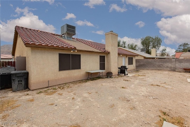 1835 Banaba Ln, Las Vegas, NV 89156 - rear view of house with a tiled roof, a fenced backyard, stucco siding, central air condition unit, and a chimney