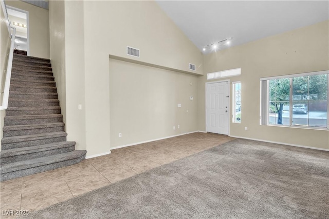 682 E Sole Addiction Ave, Las Vegas, NV 89183 - carpeted foyer entrance featuring tile patterned floors, high vaulted ceiling, stairs, and baseboards