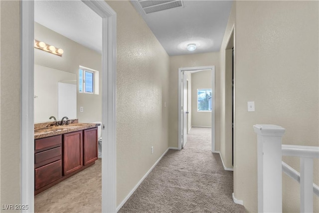 682 E Sole Addiction Ave, Las Vegas, NV 89183 - corridor featuring plenty of natural light, light carpet, a textured wall, and baseboards