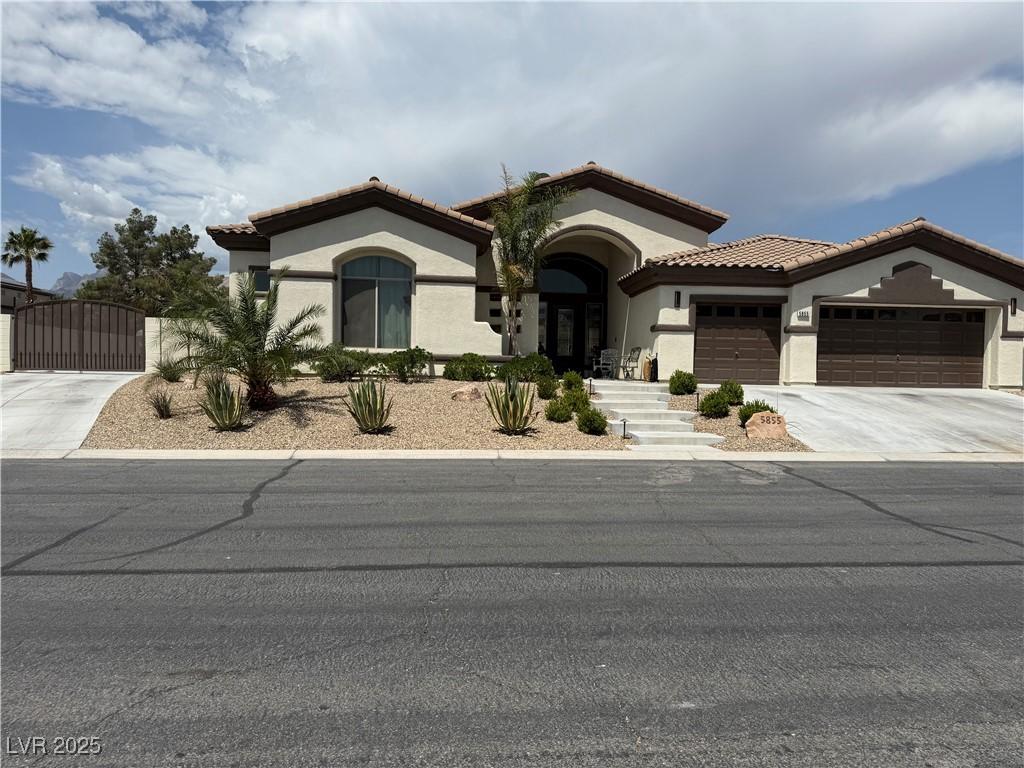 5855 Boulder Brook Ct, Las Vegas, NV 89149 - mediterranean / spanish house featuring stucco siding, a gate, driveway, an attached garage, and a tiled roof