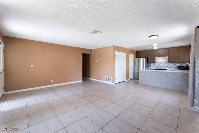 1470 Elizabeth Ave Unit 1, Las Vegas, NV 89119 - kitchen with freestanding refrigerator, tasteful backsplash, light countertops, baseboards, and light tile patterned floors