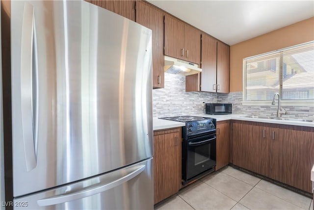1470 Elizabeth Ave Unit 1, Las Vegas, NV 89119 - kitchen with black appliances, a sink, under cabinet range hood, light tile patterned flooring, and light countertops
