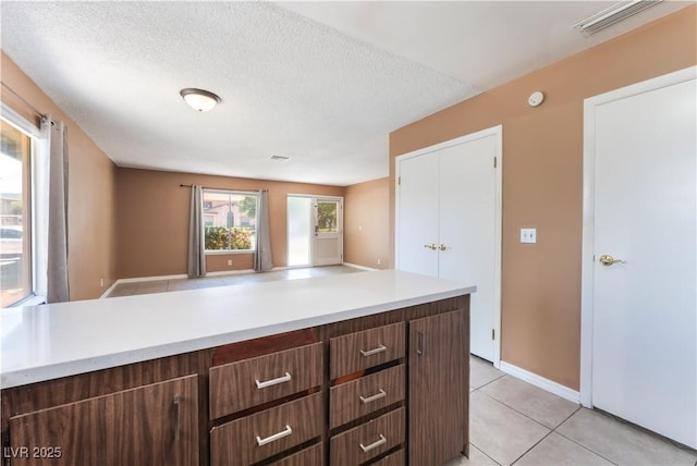 1470 Elizabeth Ave Unit 1, Las Vegas, NV 89119 - kitchen with light countertops, light tile patterned flooring, a textured ceiling, baseboards, and open floor plan