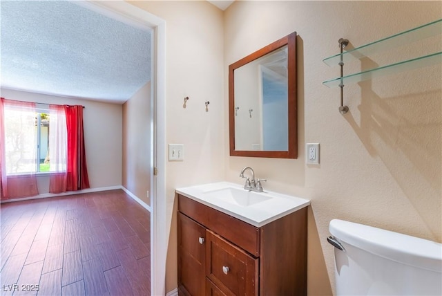1470 Elizabeth Ave Unit 1, Las Vegas, NV 89119 - bathroom with toilet, vanity, wood finished floors, baseboards, and a textured ceiling