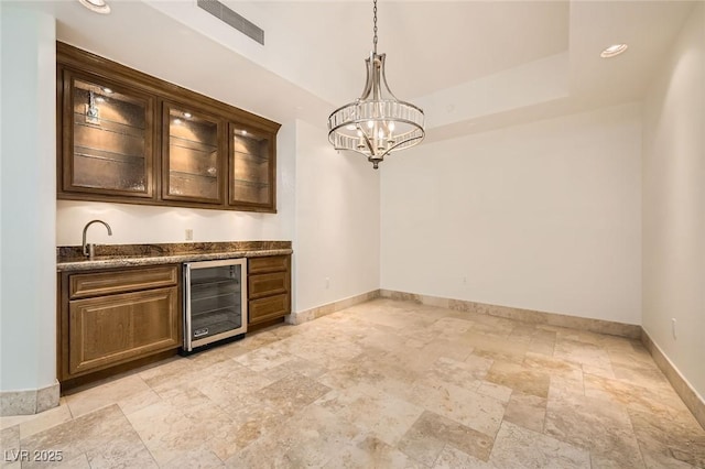9101 Alta Dr Unit 1203, Las Vegas, NV 89145 - indoor wet bar with beverage cooler, stone tile floors, baseboards, a chandelier, and hanging light fixtures