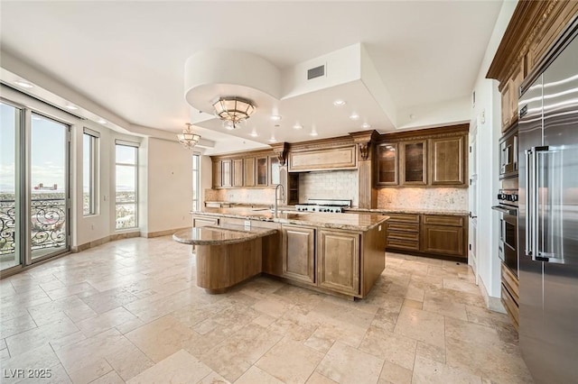 9101 Alta Dr Unit 1203, Las Vegas, NV 89145 - kitchen with stone tile floors, decorative backsplash, stainless steel appliances, baseboards, and light stone countertops