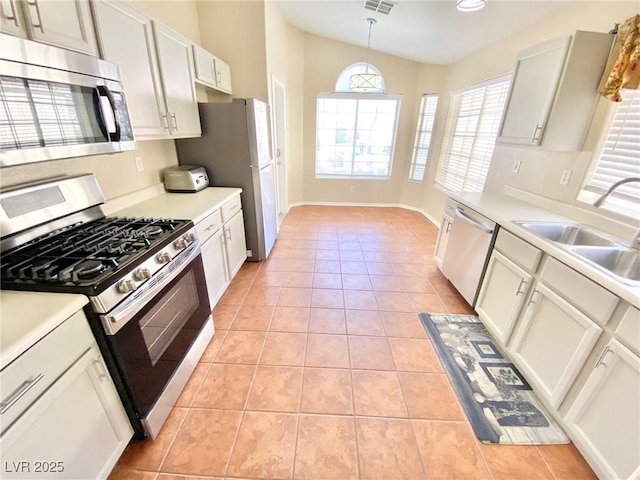 3372 Wayward Ct, Las Vegas, NV 89129 - kitchen featuring stainless steel appliances, light tile patterned floors, lofted ceiling, a sink, and light countertops