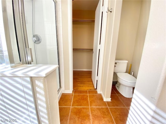 3372 Wayward Ct, Las Vegas, NV 89129 - bathroom with a shower stall, tile patterned floors, a spacious closet, and toilet