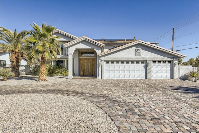 2890 Belcastro St, Las Vegas, NV 89117 - view of front of property featuring decorative driveway, stucco siding, solar panels, a garage, and a tiled roof