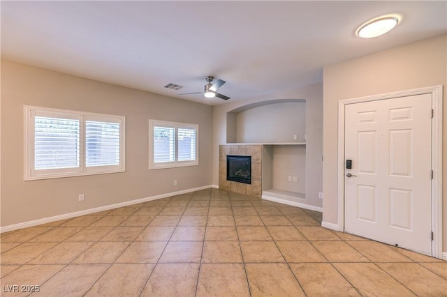 8775 Traveling Breeze Ave Unit 102, Las Vegas, NV 89178 - unfurnished living room with ceiling fan, a tiled fireplace, and baseboards