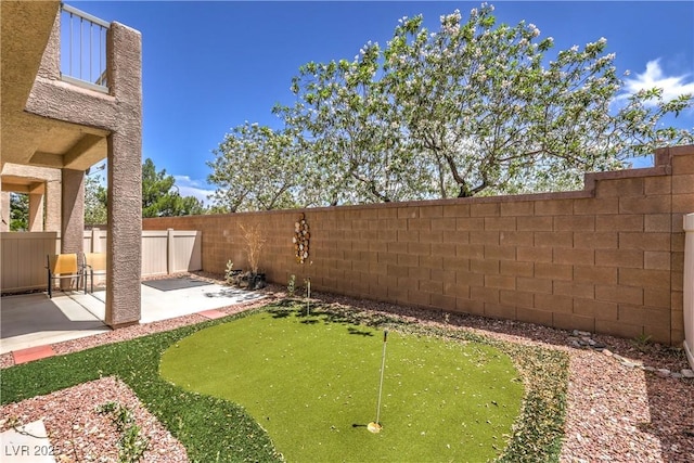 8775 Traveling Breeze Ave Unit 102, Las Vegas, NV 89178 - fenced backyard with a putting green and a patio area