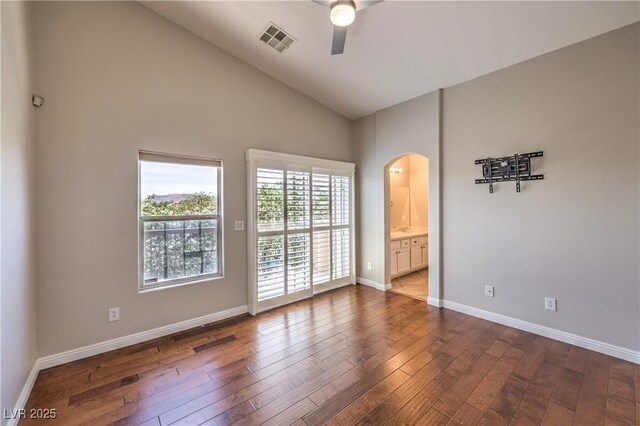 8775 Traveling Breeze Ave Unit 102, Las Vegas, NV 89178 - spare room featuring arched walkways, a ceiling fan, dark wood-type flooring, baseboards, and high vaulted ceiling