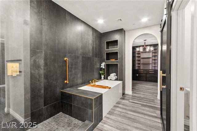 2407 Ridgeline Wash St, Las Vegas, NV 89138 - bathroom featuring wood finished floors, a bath, tiled shower, and baseboards