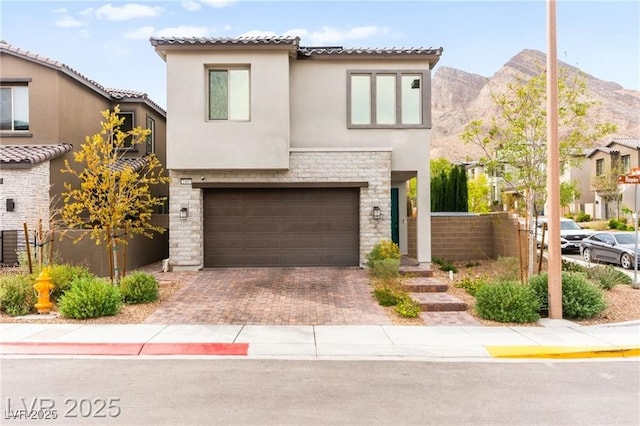 2407 Ridgeline Wash St, Las Vegas, NV 89138 - view of front facade featuring stone siding, stucco siding, an attached garage, decorative driveway, and a tile roof