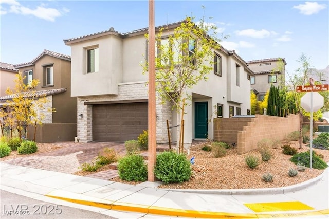 2407 Ridgeline Wash St, Las Vegas, NV 89138 - mediterranean / spanish house featuring stucco siding, a garage, stone siding, and decorative driveway