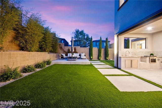 2407 Ridgeline Wash St, Las Vegas, NV 89138 - yard at dusk featuring a patio area, area for grilling, outdoor lounge area, and a sink