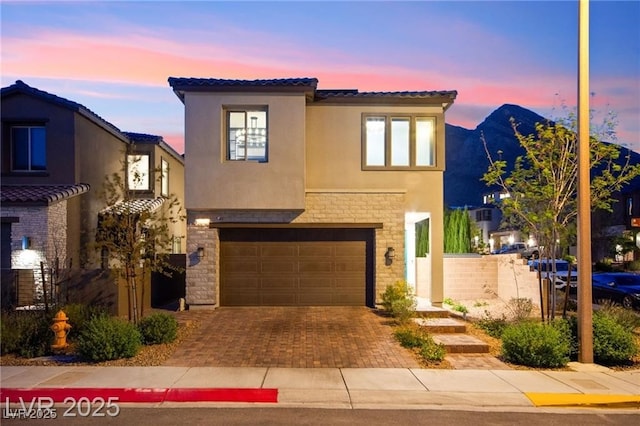 2407 Ridgeline Wash St, Las Vegas, NV 89138 - view of front of property with stone siding, a tiled roof, stucco siding, a garage, and decorative driveway