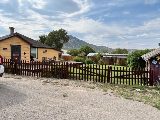 2228 Campton, Ely, NV 89301 - view of home's exterior with a mountain view, a fenced front yard, and a chimney
