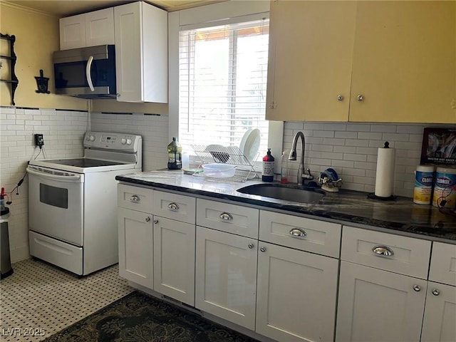 2228 Campton, Ely, NV 89301 - kitchen featuring electric stove, stainless steel microwave, a sink, white cabinetry, and dark stone countertops