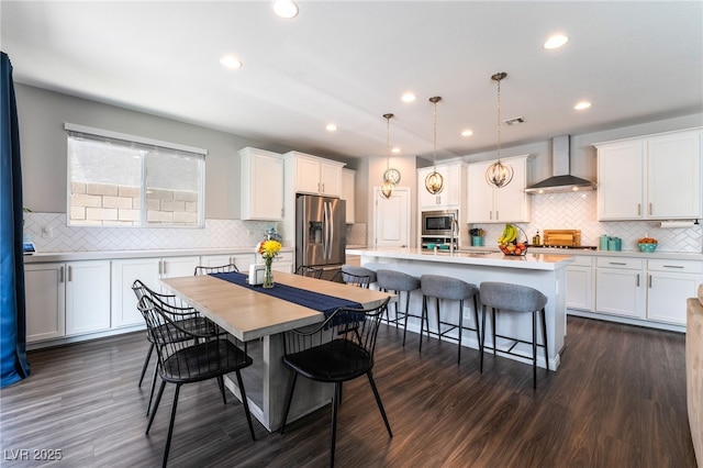 10829 Crestview Pointe Ave, Las Vegas, NV 89166 - kitchen with wall chimney range hood, appliances with stainless steel finishes, tasteful backsplash, white cabinetry, and recessed lighting