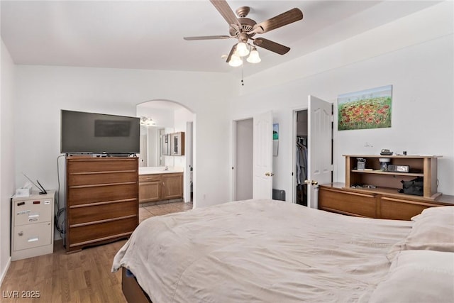 2037 Merano Ct, Las Vegas, NV 89123 - bedroom with arched walkways, light wood-style flooring, ensuite bath, and ceiling fan