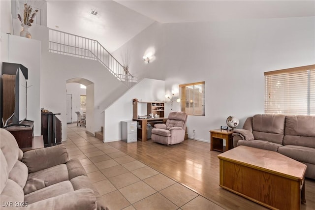 2037 Merano Ct, Las Vegas, NV 89123 - living area with arched walkways, high vaulted ceiling, light wood-style flooring, and baseboards