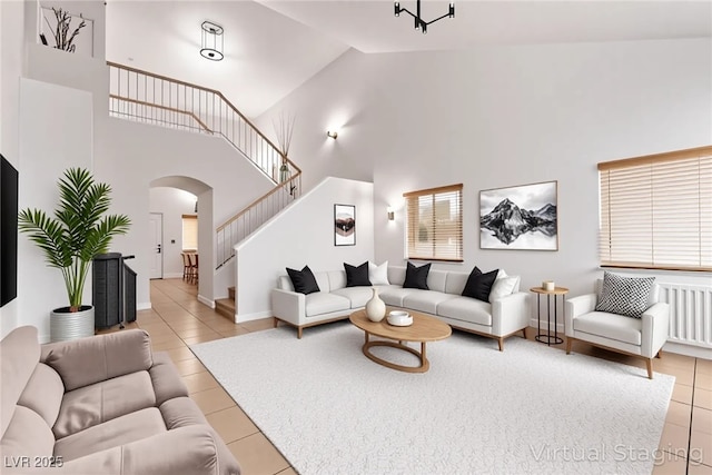2037 Merano Ct, Las Vegas, NV 89123 - tiled living area with arched walkways, high vaulted ceiling, stairs, and baseboards