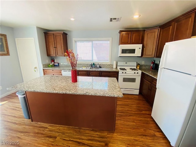 11117 Okeefe Ct, Las Vegas, NV 89144 - kitchen featuring white appliances, a center island, dark wood finished floors, light stone counters, and recessed lighting